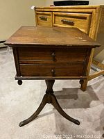 Front perspective of the antique wooden side table showing two small drawers and rectangular surface top.
