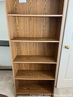 Front view of 5 shelf melamine bookcase showing woodtone finish and shelves