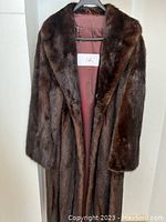 Full-length front view of the coat on hanger showing shape and color