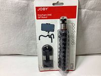 Original Joby GripTight ONE GP Stand in original blister retail packaging showing flexible tripod legs and smartphone mount.
