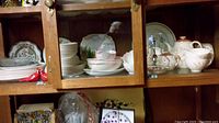 A cabinet filled with plates, cups, bowls and serving dishes of Royal Doulton Meadow Glo pattern.
