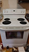 Front view of white Frigidaire electric stove showing four coil burners and oven door