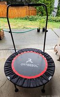 Front view of the assembled mini trampoline with handle attached, showing jumping surface with Arteesol logo and red accent ring, six legs, and handle frame.