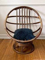 Front view showing circular rattan frame and turquoise fluffy cushion on seat.