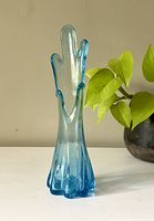 Front angle shot of blue glass vase showing finger-like extensions.