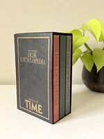 Front view of the three volumes in their slipcase, showing book cover titles and colors