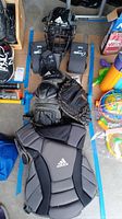 Photo of Adidas youth medium chest protector, catcher's mask, shin guards, catcher's glove and wrist guards.