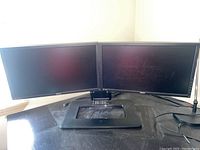 Two Asus PB238 monitors mounted side-by-side on an HP dual monitor stand on a black surface.