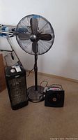 Holmes standing floor fan with Power Zone heater and Vornado fan on carpeted floor