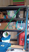 Wide photo showing full metal storage rack loaded with various storage bins and items in a garage setting.