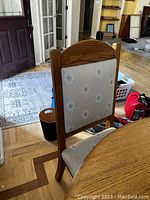 Close-up of one chair showing wooden frame and upholstered back with geometric pattern fabric.