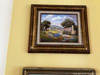 Framed oil painting of cottage with colorful flowers and trees