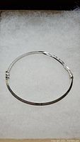 Entire hinged bangle bracelet laid flat inside box