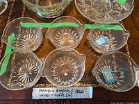 Six rinsers arranged on wood surface showing top view and starburst pattern.