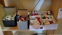 Overview of three open boxes: black box with spherical ornaments, grey box with two large mushroom ornaments, white Inge-Glas box with small mushrooms