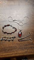 Top down photo of entire set showing necklace, bracelets, and earrings laid out on wooden surface.