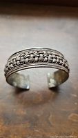 Front view of sterling silver cuff bracelet showing woven pattern and rope edges.