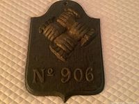 Front view of the cast iron fire insurance plaque with embossed three clasped hands and the number 906.