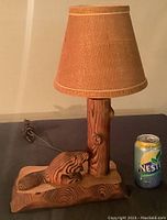 Front view of the lamp including the shade and a can for size reference