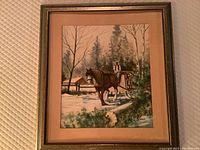 Full view of framed oil painting showing horse and buggy in a snow-covered forest landscape.