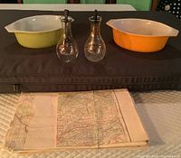 Two Pyrex casserole dishes, two Pyrex Crudit oil and vinegar bottles, and a bundle of nine contour maps of Kingston area.