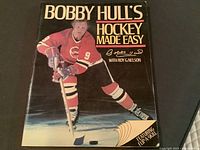 Front cover photo of the book showing the title, an image of Bobby Hull in hockey gear, and his signature printed on the cover.