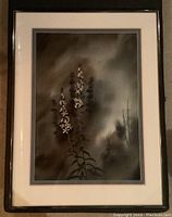 Framed watercolour painting showing white flowers against a dark, moody background with shadowed trees, matted with cream and grey mats in a dark wooden frame.
