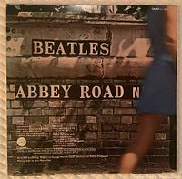 Back of the Abbey Road album cover showing street signage and track listing of the album.