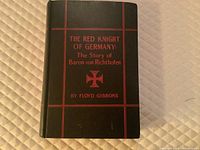 Cover of the book showing black cover with red decorative lines and lettering.