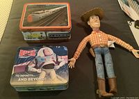 Photo of Toy Story Woody doll, Buzz Lightyear lunch box and CN train-themed lunch box