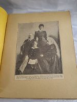 Single scrapbook page showing a historic photo of King Edward, Queen Alexandra, Queen Victoria, and a child, with a caption describing the image.