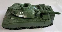 Left side view showing detailed surface textures and turret with opening hatch on the green motorized tank toy.