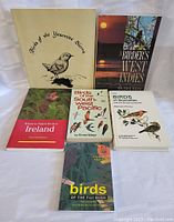 Photo showing the six bird watching reference books arranged on a white surface.