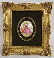 Front view of an ornate gold-tone frame with a porcelain cameo depicting a woman sitting by a basket outdoors on a dark velvet background.