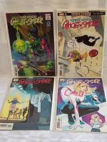 Four Marvel Ghost Spider comic books arranged on a surface showing front covers with colorful artwork.