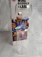 Full view of the product with packaging showing the glass and the box behind it, illustrating the scale and design of the product.