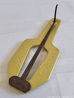 Photo showing the jaw mouth harp from a flat top view highlighting the engraved decorative brass body and metal tongue.