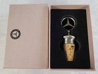 Mercedes Benz wine stopper inside original light pink box with logo on lid.