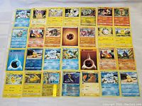 Photo displaying a spread of 31 assorted Pokémon cards including multiple Pikachu, Pachirisu, Emolga, Magnezone cards and energy cards.