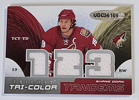 Front of Shane Doan card with tri-color jersey swatches and player image in red Arizona Coyotes uniform.