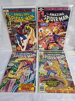 Four vintage Spider-Man comic books in protective plastic sleeves arranged in two rows of two, showing front covers.
