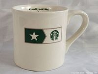 Side view of the Starbucks military collectors mug showing the green military star emblem and Starbucks logo on an off-white ceramic surface.