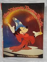 Cover of The Disney Poster Book featuring Mickey Mouse in the Sorcerer's Apprentice robe and hat, illustrating the Disney poster art theme.