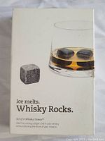 Closed box featuring the product name and usage description with an image of whisky stones in a glass of whisky.