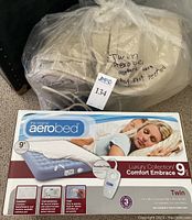 Unboxed AeroBed twin inflatable mattress in clear plastic bag labeled 'Twin AeroBed, appears clean but not tested'.
