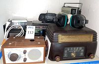 Wide shot showing all radios, boom box, and headphones together for a full view of the lot contents