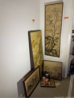 Full view of all Asian art pieces including mounted paintings, framed fabric, wood-mounted paintings, and Japanese figurines on tatami base.