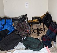 Overview of the lot showing various backpacks, sport bag, lunch bag, and fanny packs arranged together