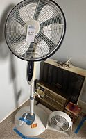Photo of five devices including a Bionaire tall standing fan, Arvin heater, Windy fan, Holmes fan, Edison box fan.