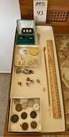 Complete overview of men's jewelry items and coins displayed together including cufflinks, pins, cross necklace, tie clip, and assorted coins in sections